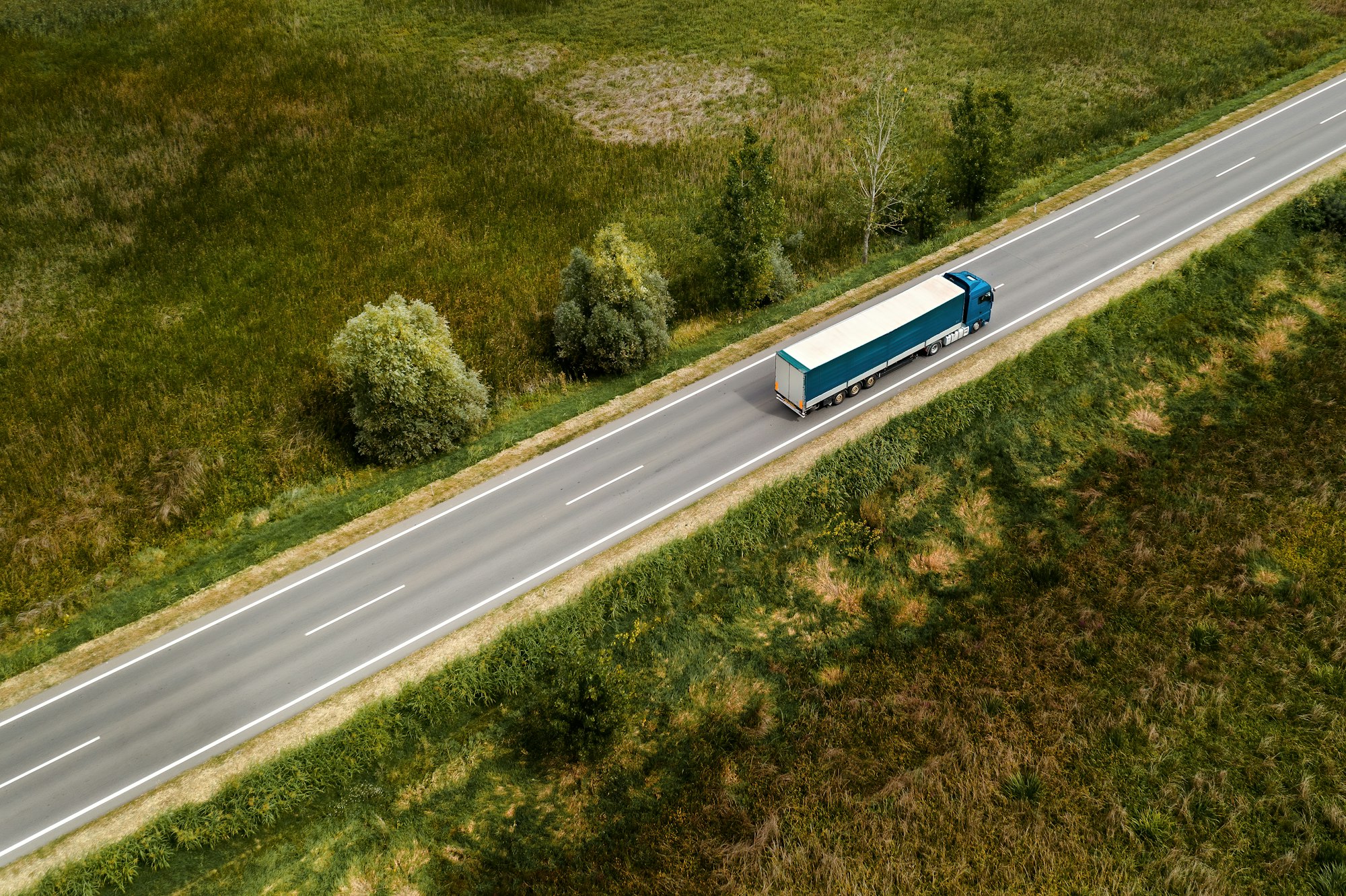 Large freight transporter semi-truck on the road, aerial view