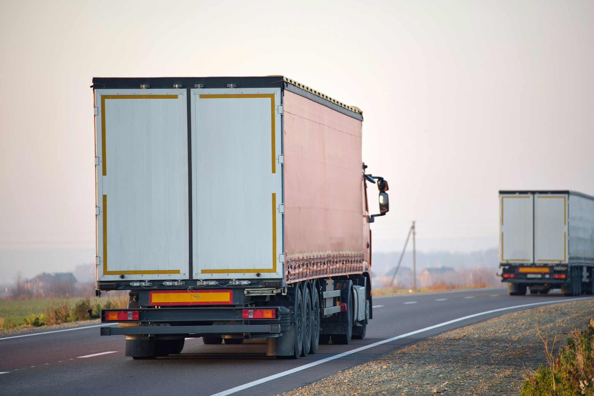 Semi-truck with cargo trailer driving on highway hauling goods in evening. Delivery transportation